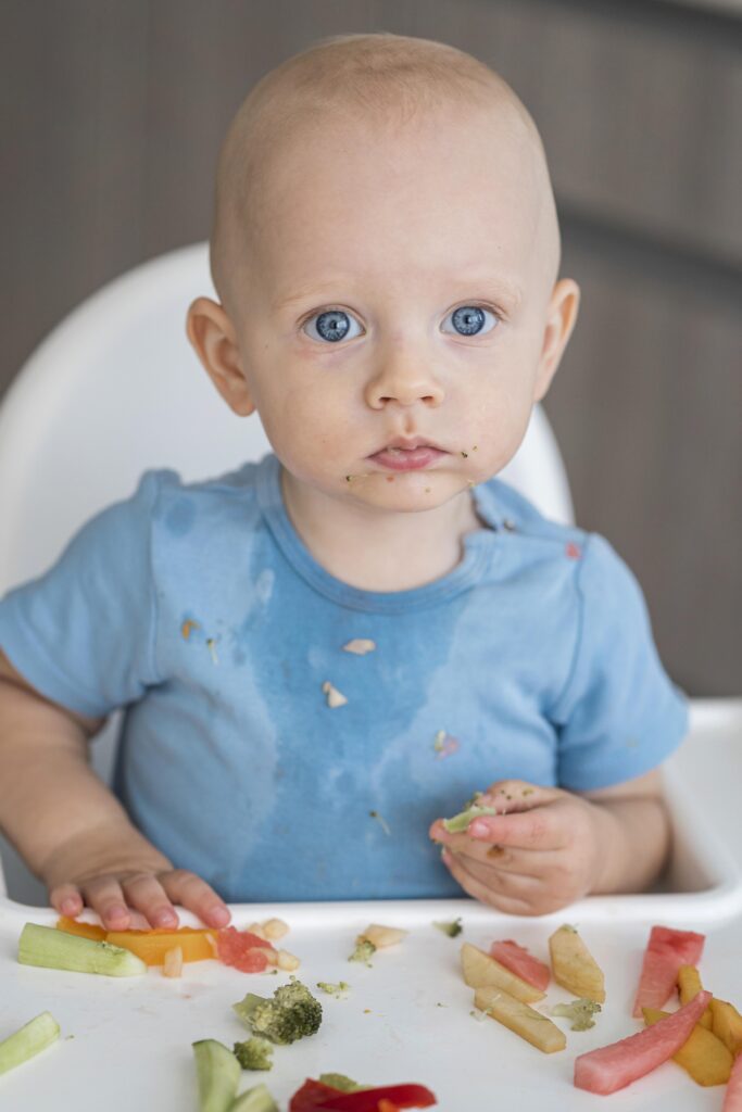 adorable baby playing with food